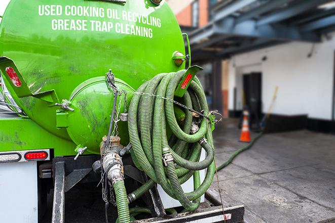 a service truck pumping grease from a restaurant's grease trap in Aroma Park